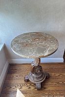 Full view of side table showing marble top and carved base