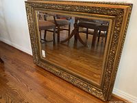 Front view of mirror leaning against wall showing overall condition and frame design