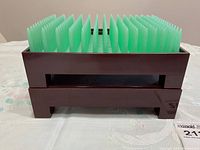Front view of dark brown desk organizer with evenly spaced vertical green dividers.