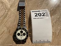 Whole watch with bracelet fully extended, showing face and bracelet length.