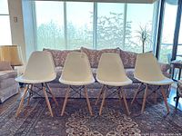 Front view of all four white molded plastic chairs lined up