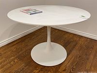 Full view of round table top and pedestal base against wall