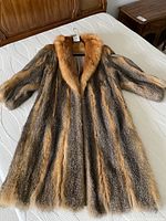 Full view of vintage full-length red fox fur coat laid flat