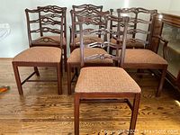 Front view of all eight chairs grouped together showing ladder-back design and seat upholstery.