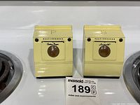 Pair of vintage Westinghouse washer and dryer salt and pepper shakers seen from the front with identifying label visible