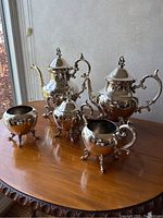 Front view of all five service pieces on wooden table