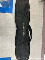 Black Dakine soft snowboard travel case lying flat
