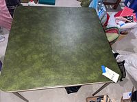 Top view of the 34-inch square green faux leather folding table showing the surface texture and color.