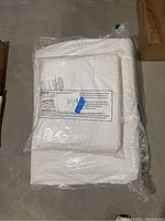 White quilts packaged in plastic wrap, shown folded, with tags attached