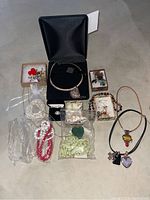 Image showing the full assortment of costume jewelry including bracelets, earrings, pendants, and the sterling silver necklace with shell pendant in its black box.