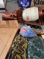 Side view of orange metal concrete mixer toy truck and bags of toy soldiers in green, brown, and blue/red colors.