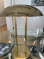 Full front view of lamp showing dome shade, dual rod supports, and circular base.