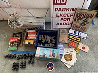 Lot arranged with chess pieces, cards, patches, signs, and books visible