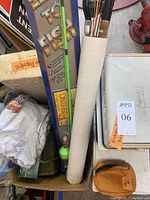 Fishing poles in original and plain packaging, fishing accessories, tackle boxes and apparel piled in a box