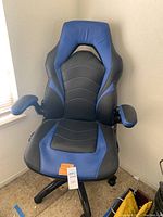 Front view of the blue and black padded gaming office chair with adjustable armrests, showing the shape and color distinctly.