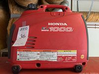 Side panel showing Honda EU1000i branding, warning labels and fuel cap location.