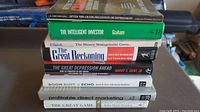 Stack of seven investing and finance books viewed from the side showing titles and authors.
