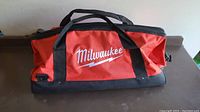 Front angled view of Milwaukee tool bag on a flat surface showing overall shape, colors, and logo.