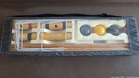 Top view of the croquet set in the black carry case showing mallets, balls, wickets, and stakes arranged neatly in foam.