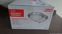 Box showing Project Source branding and image of the two flushmount ceiling fixtures with frosted glass domes and brushed metal trim.