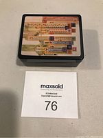Top-down view of small black lacquer trinket box with colorful geometric decorative cover inspired by Frank Lloyd Wright's style.