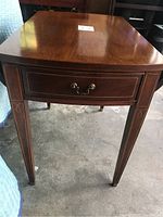 Front view showing drop leaf end table with a single drawer, brass handle, and detailed legs.