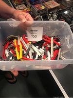 Plastic bin containing assorted Lego Robotics and Technic beams and connector pieces in various colors and sizes.