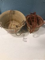 Top-down view showing interior of both clay planters with rawhide hanging cords inside.