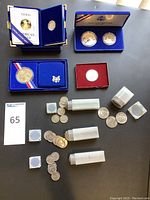 Overview of lot contents showing display boxes, coin tubes and loose coins