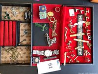 Open jewelry box showing left and right compartments with various jewelry