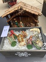 Photo showing entire nativity set including stable and all figurines in a box with shredded paper packing