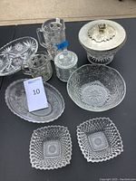 Full set of vintage glass serving ware items arranged together showing pitcher, covered jar, ice bucket, plates and bowls