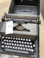 Vintage Royal Arrow portable typewriter in black carrying case, visible keys and body details.