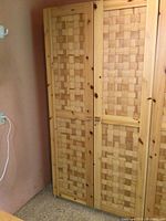 Full front view of two tall pine lattice front cabinets standing side by side showing the woven wood pattern on doors and overall condition.