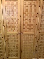 Front view of two-door pine cabinet with woven lattice panels