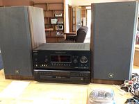 Front view with Sony receiver stacked above 5 disc CD changer, two JBL speakers on each side, cords laid out.