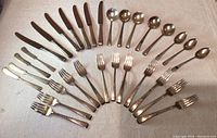 Full overview of flatware arranged by type including knives, forks, spoons and ladles.
