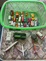 Top view of basket with various toy cars and trucks in multiple colors arranged inside