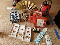 Overview of Japanese decor items: wind chime, fan, red paper lantern, boxed charms, small figures, fabric items, and decorative items.
