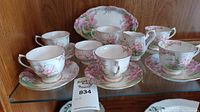Full set of 6 teacups with matching saucers, one creamer, one sugar dish, and serving tray displayed on shelf