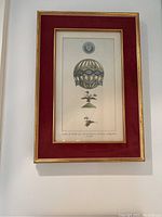 Full view of 1804 hot air balloon print framed with red velvet mat and gold frame.