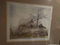 Framed limited edition print titled 'La Maison' showing a rustic barn and house with tree and fence in monochrome tones.
