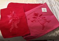 Blanket and pillowcase unfolded showing both blanket colors and angel design.