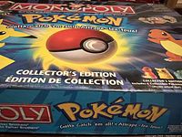 The Pokémon Monopoly Collector's Edition box with colorful artwork and logo, showing the title and slogan.