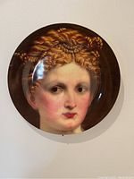Full view of the decorative portrait plate showing the woman's face and elaborate hair design.