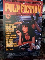 Full front view of the Pulp Fiction poster showing Uma Thurman in black reclining pose with cigarette and gun, including all text credits and title.