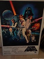 Full view of the Star Wars poster showing all primary characters and the Death Star in a space background, including bottom credit block.