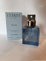 Light blue rectangular glass bottle of Calvin Klein Eternity Aqua for Men, with silver spray nozzle and blue text reading 'ETERNITY for men AQUA Calvin Klein', shown together with matching light blue boxed packaging.