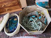 Two open boxes containing assorted bead and metal jewelry pieces