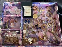 Overall view of jewelry and watches arranged in floral-patterned tray